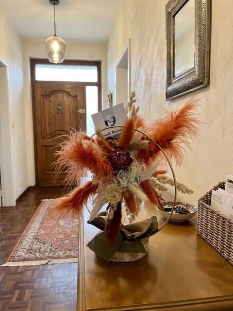Droogbloemarrangement van Bloom & Gift Studio in een hal